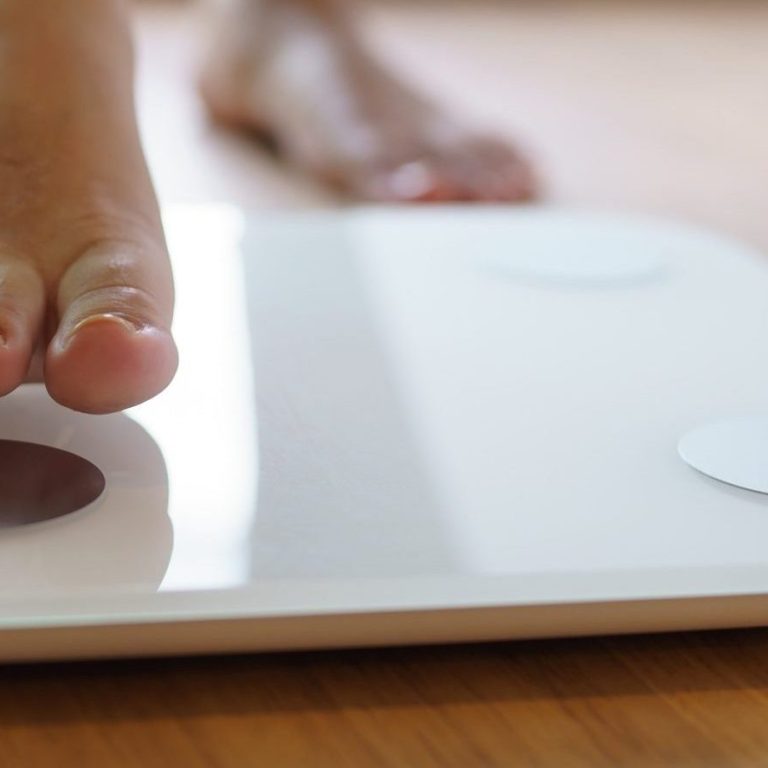 Lose weight. Fat diet and scale feet standing on electronic scales for weight control. Measurement instrument in kilogram for diet